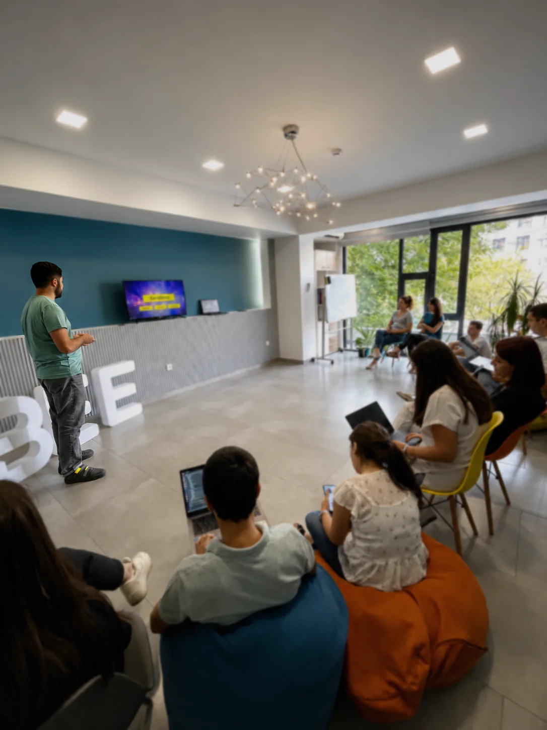 Samvel Antapyan presenting to colleagues seated with laptops at the BeeWeb office